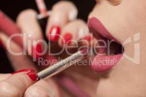beautician applying lipstick to a model