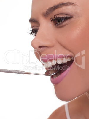 smiling woman holding a dental mirror in her mouth