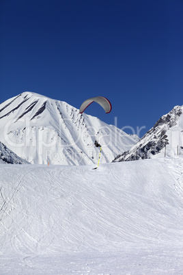 skydiver landing on ski slope