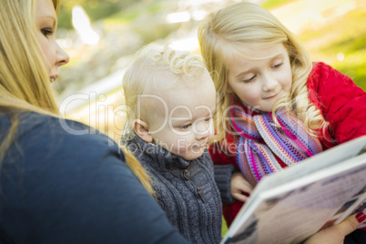 mother reading a book to her two adorable blonde children.