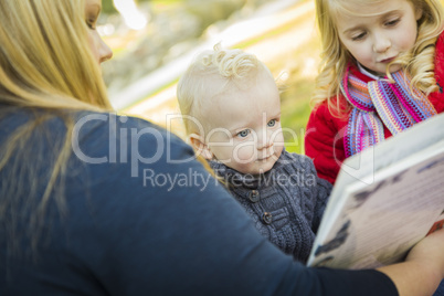 mother reading a book to her two adorable blonde children.