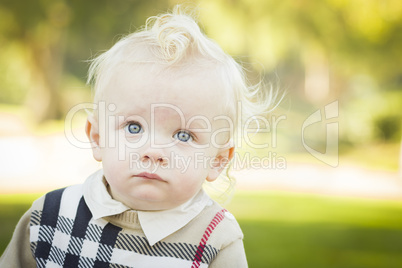 adorable blonde baby boy outdoors at the park.