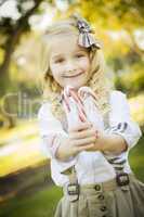 cute little girl holding christmas candy canes outdoors.