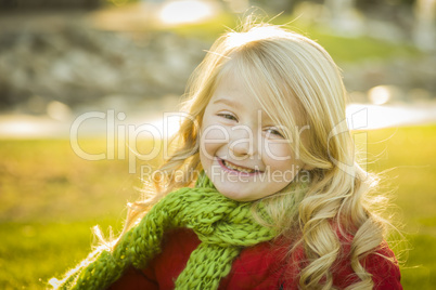 little girl wearing winter coat and scarf at the park.