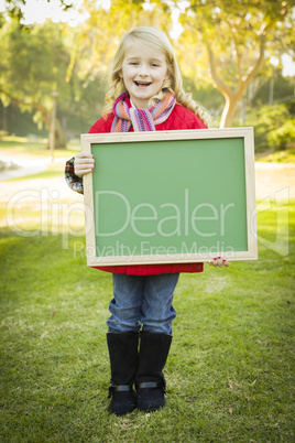 cute girl holding a green chalkboard wearing winter coat outdoor