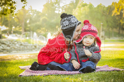 little girl whispers a secret to baby brother outdoors