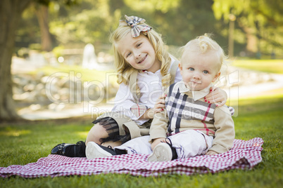 Sweet Little Girl Hugs Her Baby Brother at the Park.