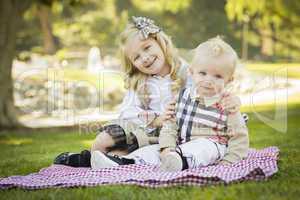 Sweet Little Girl Hugs Her Baby Brother at the Park.