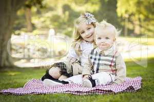 Sweet Little Girl with Her Baby Brother at the Park.