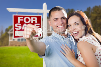 military couple in front of home, house keys and sign