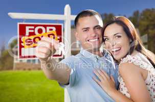 military couple in front of home, house keys and sign