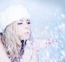 beautiful woman blowing snowflakes