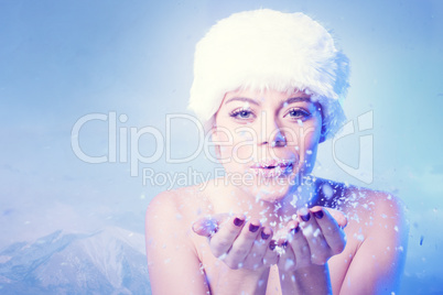 beautiful young woman blowing winter snow