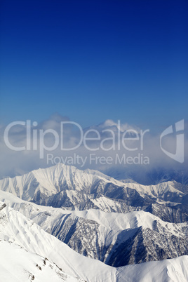 winter snowy mountains and blue sky with clouds