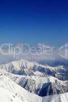 winter snowy mountains and blue sky with clouds