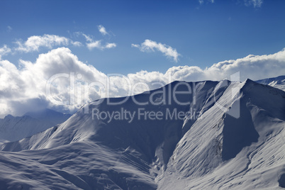 off piste slope in evening with sunlit clouds