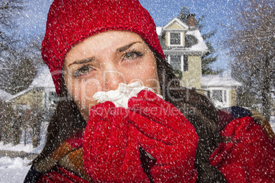 sick woman in snow blowing her sore nose with tissue