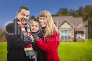 happy mixed race family in front of house