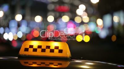 city traffic at night behind taxi sign
