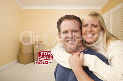 couple in new house with boxes and sold sale sign