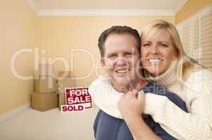 couple in new house with boxes and sold sale sign