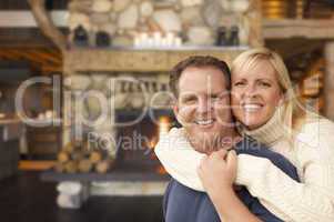 affectionate couple at rustic fireplace in log cabin