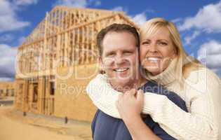 couple in front of new home construction framing site