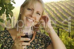 attractive woman enjoying a glass of wine at the vineyard