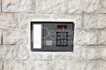 An intercom doorbell and access code panel on the wall.