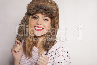 beautiful happy young woman in a furry winter hat