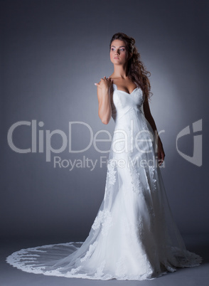 Beautiful slim bride posing in elegant long dress