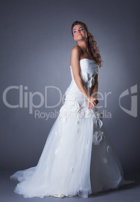 Dreamy brunette posing in elegant wedding dress