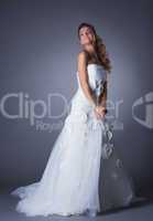 Dreamy brunette posing in elegant wedding dress
