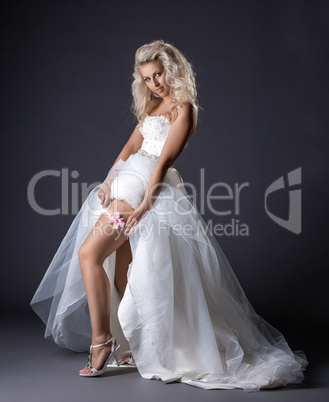 Image of sensual young bride shows garter on leg
