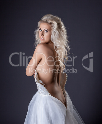 Portrait of curly blonde posing in wedding dress