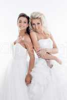 Smiling young girls posing in wedding dresses