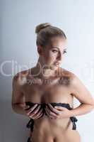 Graceful slim blonde posing in black bra