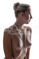 Alluring young woman in pearl beads posing nude