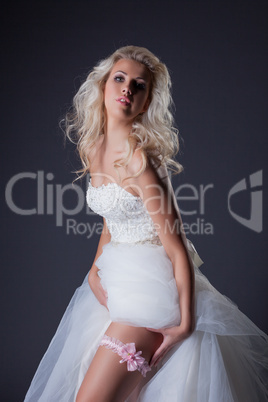 Seductive blonde posing in chic wedding dress