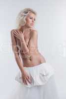 Dreamy young bride posing topless in studio