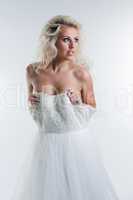 Sensual young blonde taking off wedding dress
