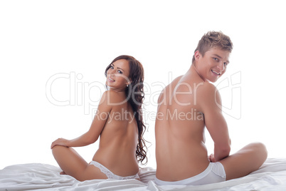 Smiling half-naked man and woman posing in bed