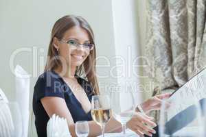 Smiling beautiful girl in glasses posing with menu