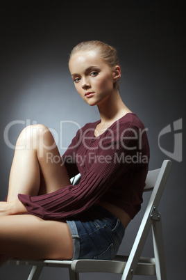 Portrait of cute young woman sitting on chair