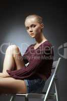Portrait of cute young woman sitting on chair