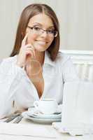 Smiling business woman sitting at table, close-up
