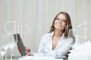Cute smiling woman in glasses works on notebook