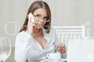 Pretty young business woman talking on cell phone
