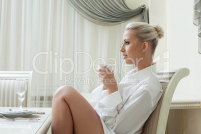 Profile of attractive young blonde drinking coffee