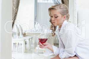 Beautiful girl thoughtfully looks at glass of wine
